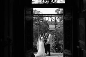 Bride and groom having their ceremony, captured by the photographer through the door - brisbane wedding photographer