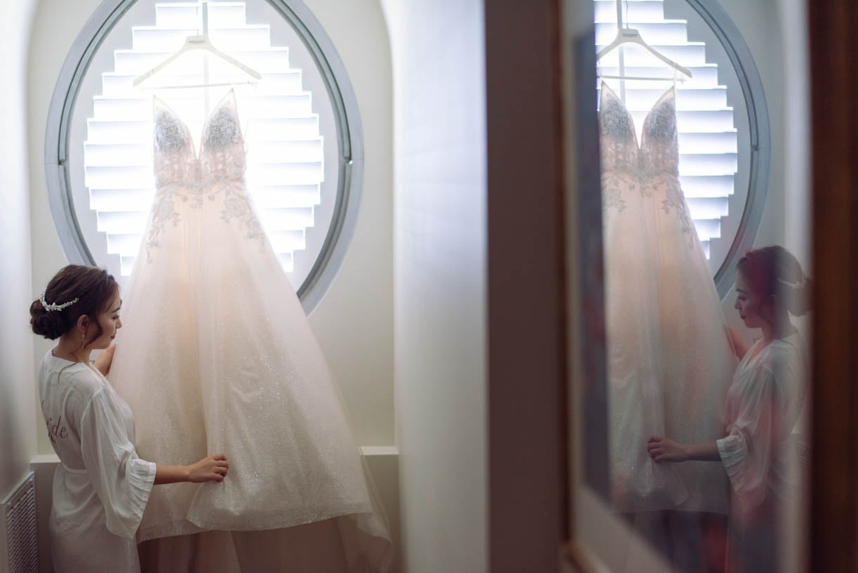 The bride is gently touching her wedding dress - brisbane wedding photographer