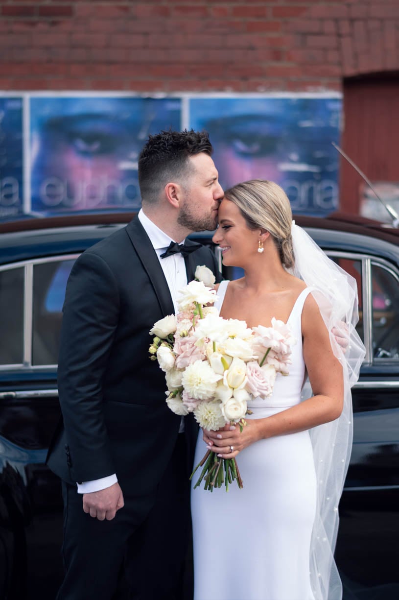 The groom is kissing the bride’s forehead - brisbane wedding photographer 