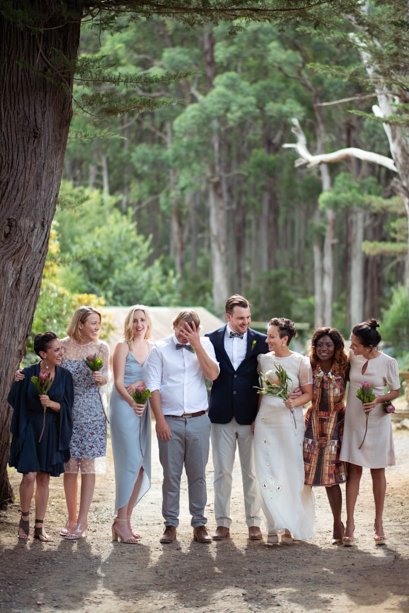 The bridesmaids and the couple are laughing together in front of the forest - brisbane wedding photographer 